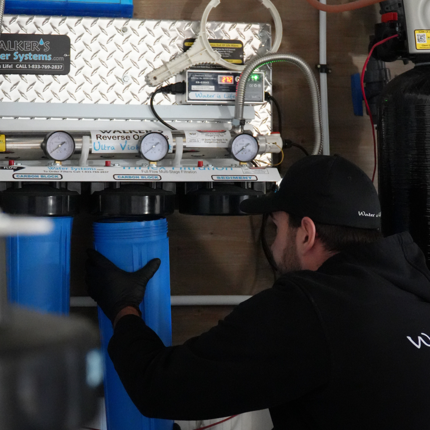 Image of Walkers Water worker replacing a filter for regular maintenance on a reverse osmosis system.
